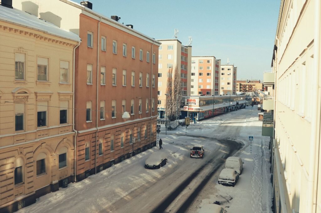 Lumihuurrettuja katuja ja rakennuksia Jönköpingissä, Ruotsissa kirkasta sinistä taivasta vasten.
