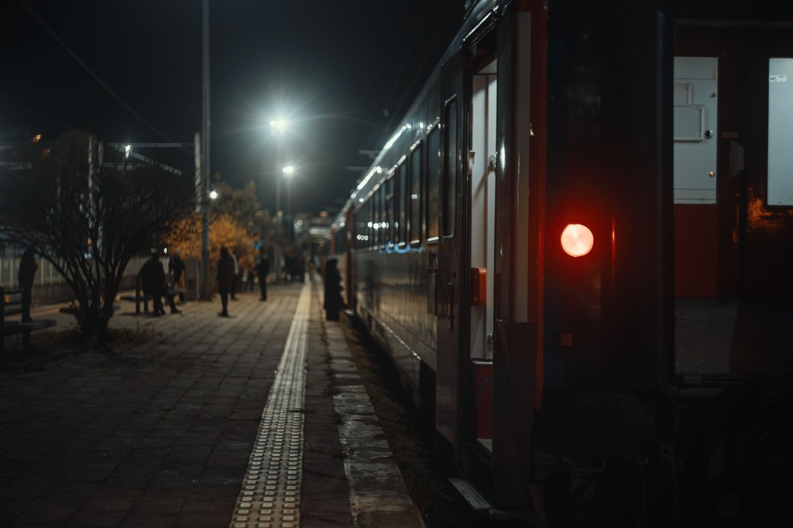 Matkustaja odottaa junaa Jämsän asemalla illalla