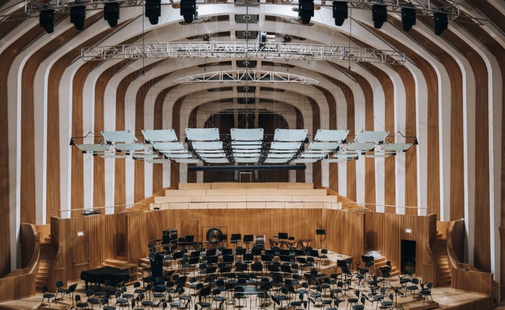 Kansanmusiikkikonsertin sali sisältä, puiset seinät ja tyhjä katsomo lämpimässä valaistuksessa
