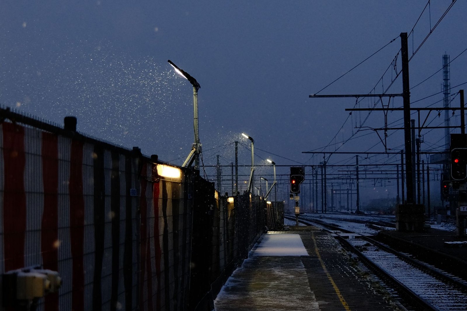 Yöjunamatkustaja seisoo rauhallisella asemalaiturilla Jyväskylässä talvella