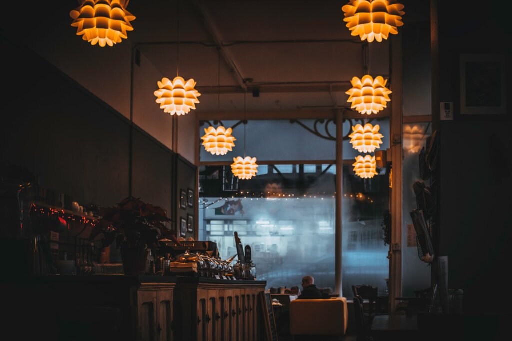 Rauhallinen kahvila sisältä, jossa on puupöytiä ja lämmin valaistus