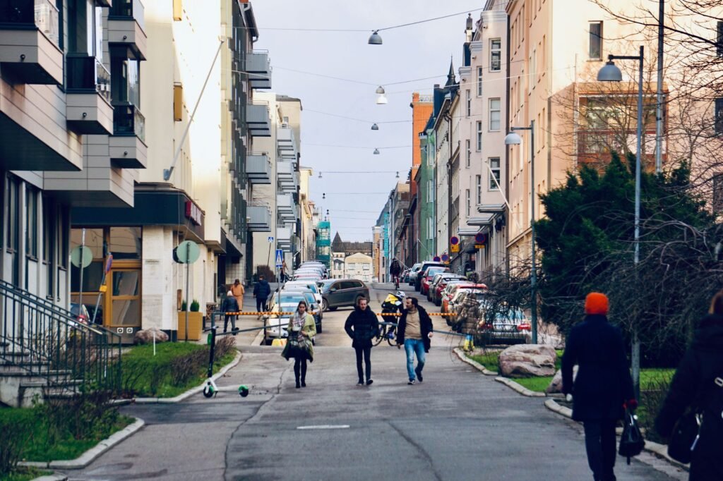 Vibrantti katu Symboleerim Helsinki, Suomessa, jossa jalankulkijat vaeltavat kaupunkirakennusten keskellä.