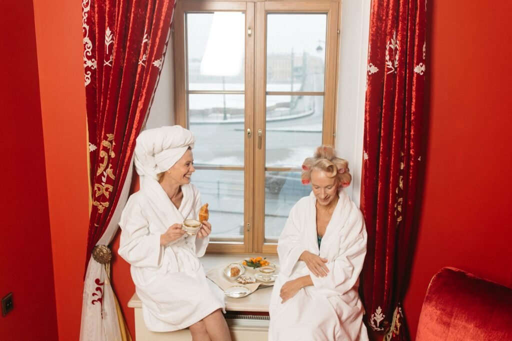 Hotellihuone aamulla, sänky ja kaksi kahvikuppia pöydällä.