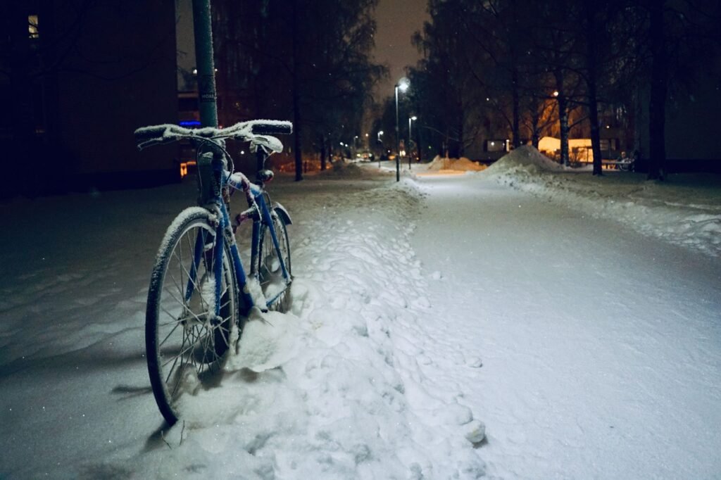 Aikuinen kävelee valaistulla kadulla Oulun keskustassa