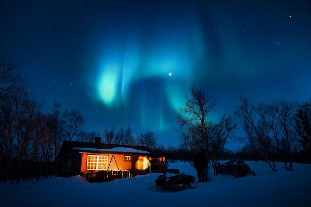 Mökin sisätila kahvikuppeineen ja ikkunanäkymällä lumiseen maisemaan