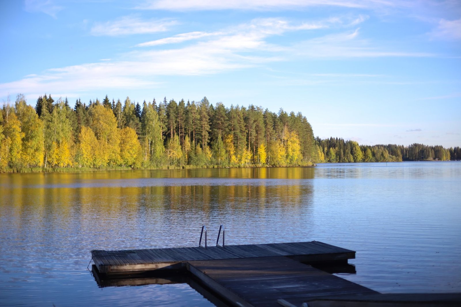 Rauhallinen järvimaisema Siilinjärvellä iltahämärässä, laituri ja metsää