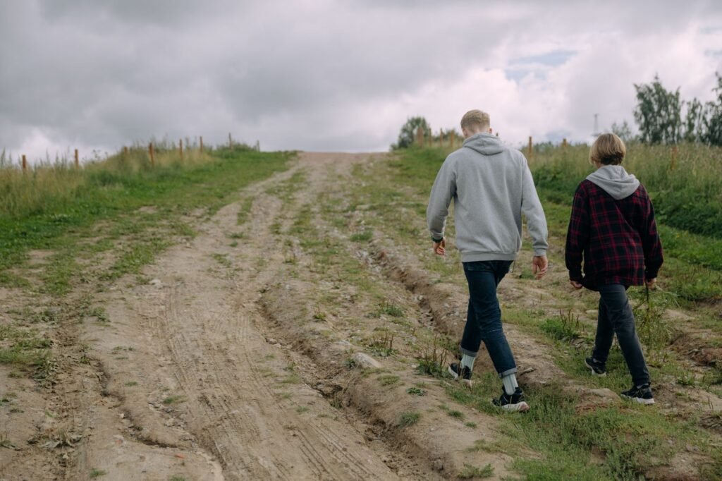 Henkilö kävelemässä hiljaisella tiellä valoisana kesäyönä Lapissa