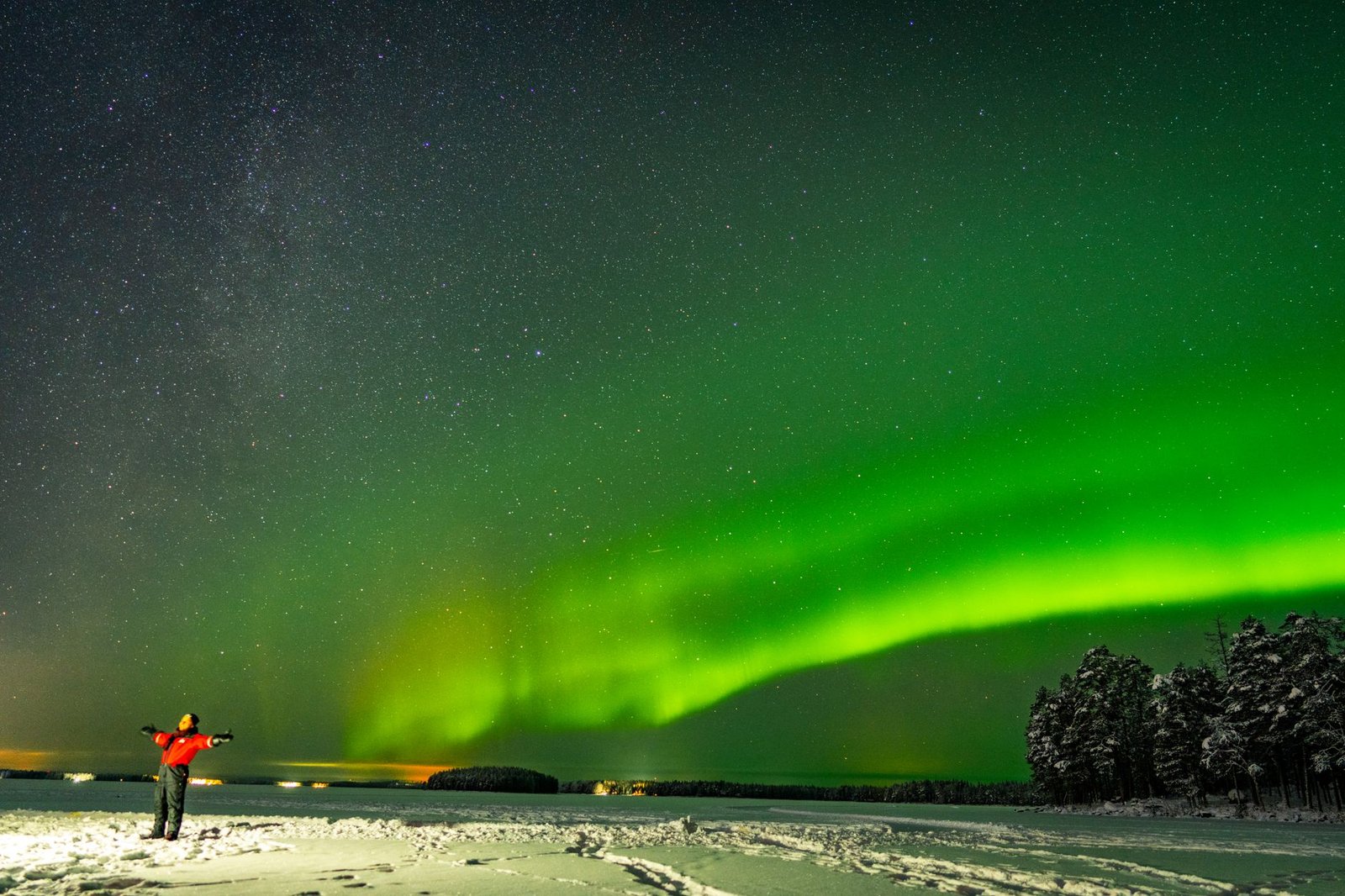 Talvinen katu Rovaniemellä illalla, lämmin valaistus ja henkilö kävelemässä
